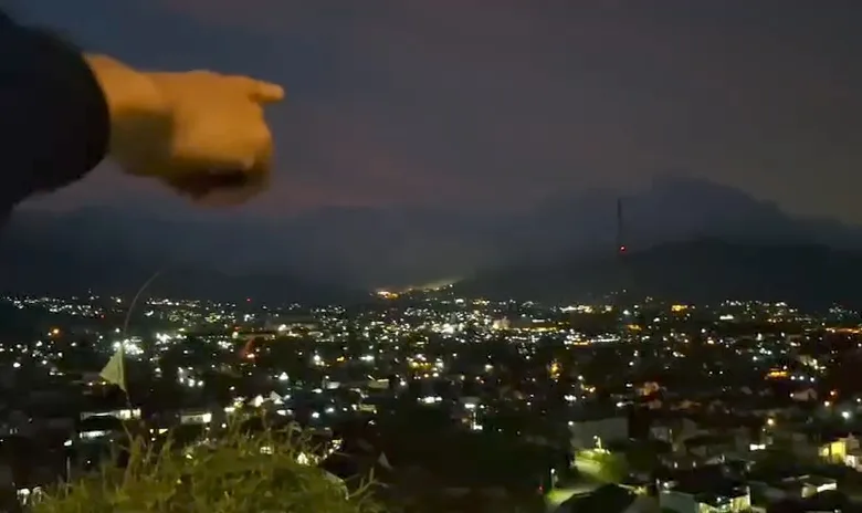 Seorang warga menunjuk ke arah pegunungan dari kawasan Gunung Kasur, Cipanas, lokasi terdengarnya suara dentuman misterius yang dilaporkan terjadi hingga tiga kali pada Kamis malam (8/1/2026).