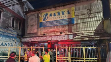 Petugas pemadam kebakaran bersama warga melakukan pengecekan usai kebakaran yang menghanguskan neon box dan sebagian atap Ruko Sanya di Jalan Dr Muwardi, Cianjur, Rabu (14/1/2026).