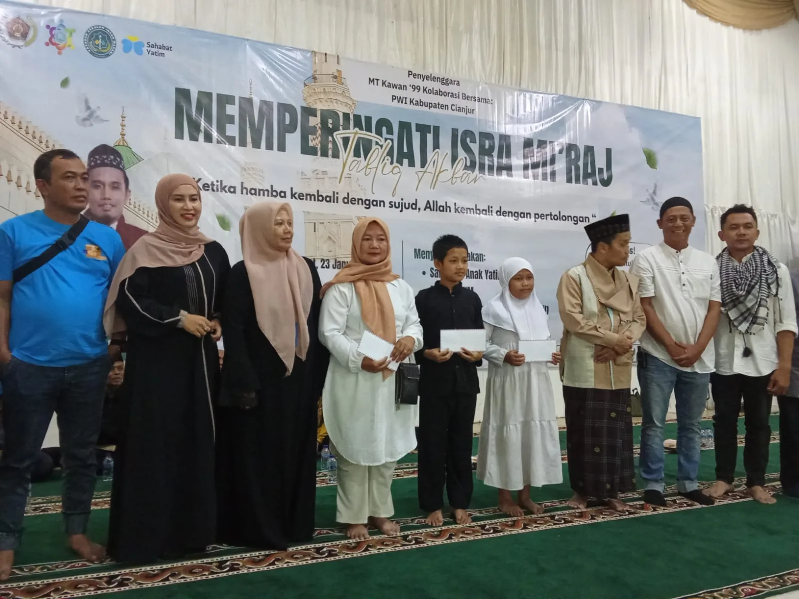 PWI Cianjur bersama MT Kawan ‘99 menyerahkan santunan kepada anak yatim dalam rangka Tabligh Akbar peringatan Isra Mi’raj Nabi Muhammad SAW 1447 H yang menghadirkan Ustadz Maulana di Gedung Assakinah, Cianjur, Jumat (23/1/2026).