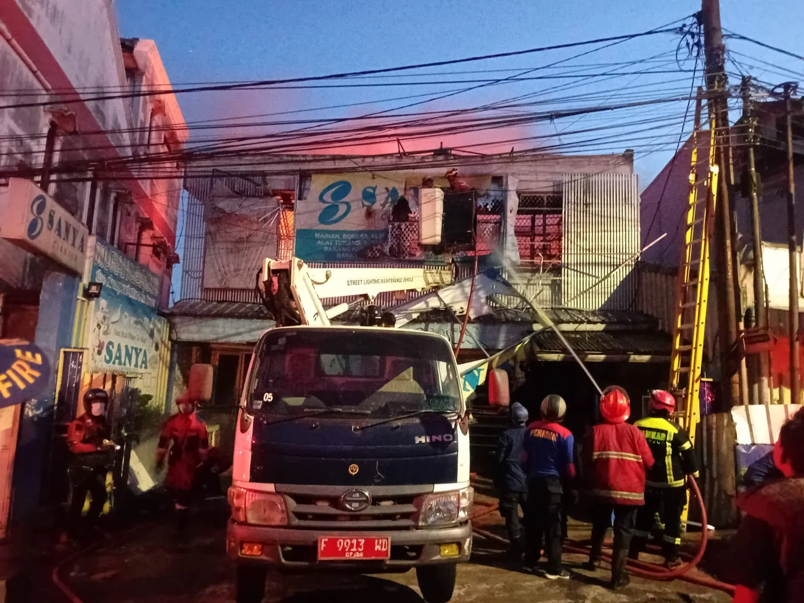Petugas pemadam kebakaran dibantu aparat kepolisian dan instansi terkait berjibaku memadamkan kebakaran hebat yang melanda Toko Sanya di Jalan Dokter Muwardi, Cianjur, Sabtu (24/1/2026).