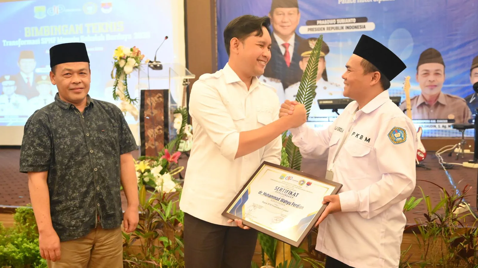 Bupati Cianjur, Mohammad Wahyu Ferdian (tengah) didampingi Kepala Disdikpora (kiri) berjabat tangan dengan Ketua DPD FK PKBM, Deni Abdul Kholik (kanan) usai membuka Bimtek Pendidikan Kesetaraan di Cipanas, Jumat (13/2/2026).