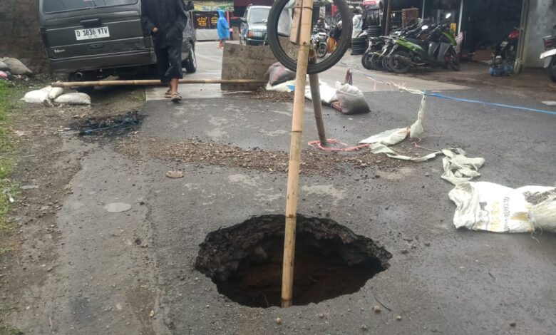 Lubang besar muncul di badan Jembatan Jeprah, Kampung Jeprah (Bengkok), Desa Sindanglaya, Kecamatan Cipanas, Kabupaten Cianjur, Minggu (8/3/2026). Warga memasang penanda sederhana dan memberlakukan sistem buka–tutup kendaraan karena di bawah permukaan jalan terdapat rongga sedalam sekitar tiga meter akibat erosi aliran air. Foto: Istimewa