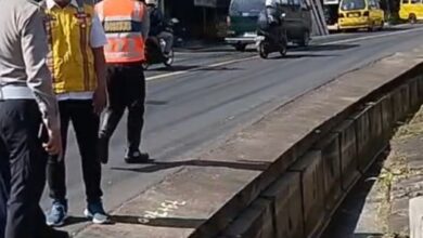 Petugas Satlantas Polres Cianjur menunjuk ke arah saluran drainase terbuka di bahu jalan Cipanas-Cianjur, Desa Cipendawa, Senin (30/3/2026).