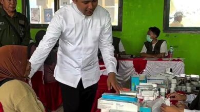 Bupati Cianjur Mohammad Wahyu Ferdian (pakaian putih) berinteraksi dengan seorang warga wanita di stan pelayanan kesehatan gratis di Desa Sukamulya, Kecamatan Naringgul, Kamis (21/5).