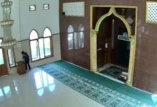 Kamera pengawas merekam keberadaan seorang pria berpakaian gelap yang tengah mendekati kotak amal di ruang salat utama Masjid Al Balad, Kampung Cinangsi, Kabupaten Cianjur. Tangkapan layar ini merupakan bukti rekaman dari dugaan aksi pencurian uang kotak amal yang terjadi pada Rabu (17/6/2026) pagi.